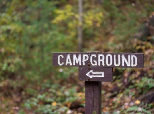 closeup-of-a-wooden-campground-sign-with-arrow-alo-RFTU6YC.jpg
